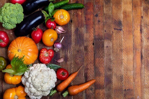 Harvest of fresh farm vegetables on old rustic weathered vintage wooden table View above Copy space