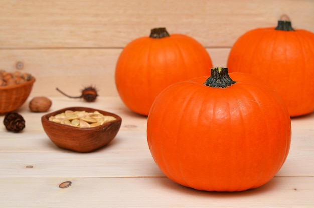 Harvest orange pumpkins on a light wooden background close up