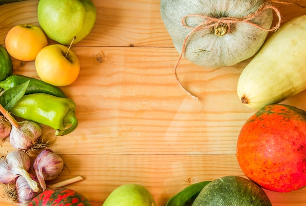 Harvest or Thanksgiving background with autumn fruits and gourds on a rustic wooden table