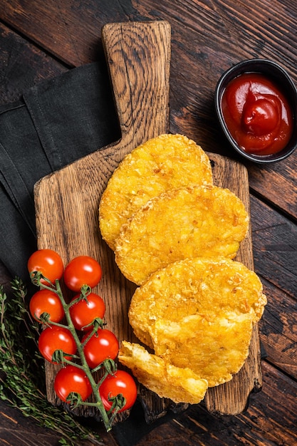 Hash brown potato Potato Patties on a wooden board with ketchup Wooden background Top view