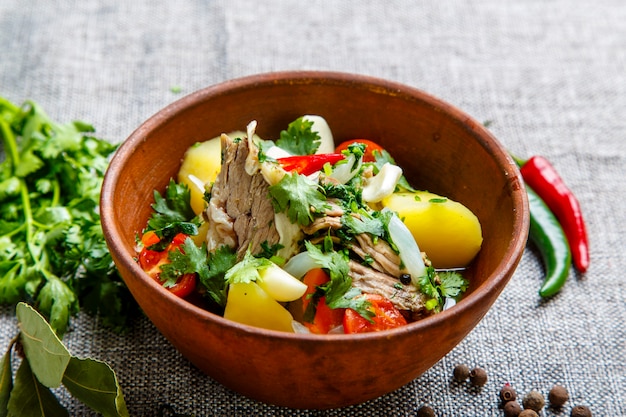 Hashlama in a clay plate. Ingredients Beef ribs, potatoes, herbs, garlic.