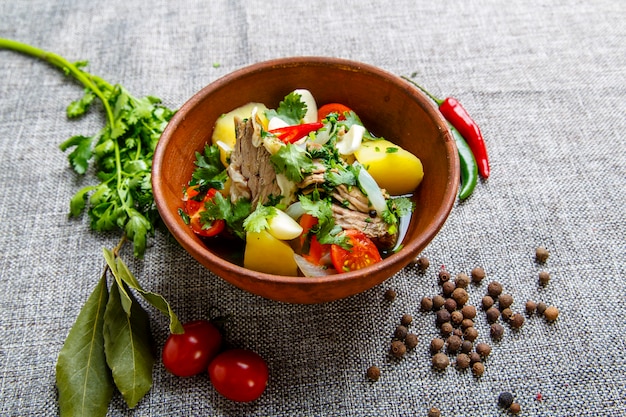 Hashlama in a clay plate. Ingredients Beef ribs, potatoes, herbs, garlic.