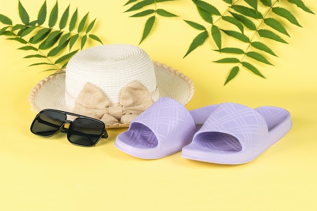 Hat slates and sunglasses on a yellow background The concept of a holiday by the sea