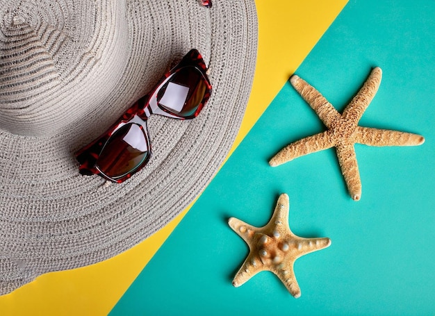 A hat and sunglasses on a yellow and green background with starfish and a hat