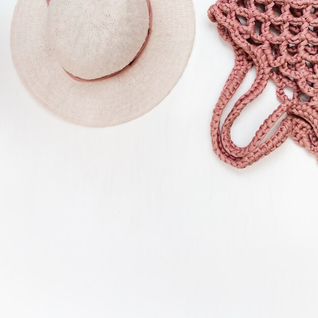 Hat for woman and stylish bag on light table. Vacation concept. Flat lay. 