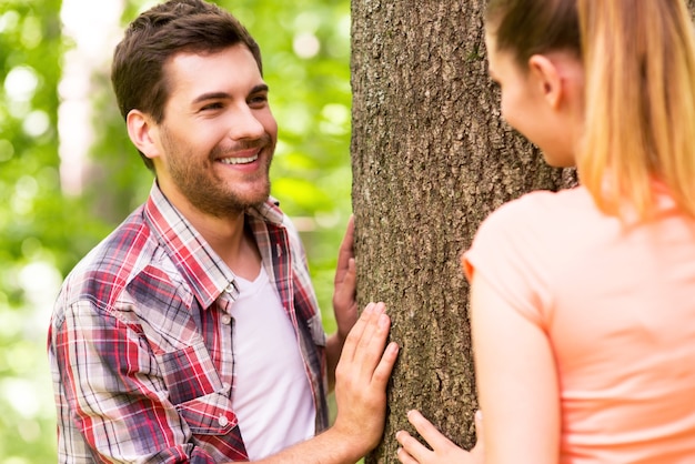 Having fun in nature. Playful young loving couple having fun in park