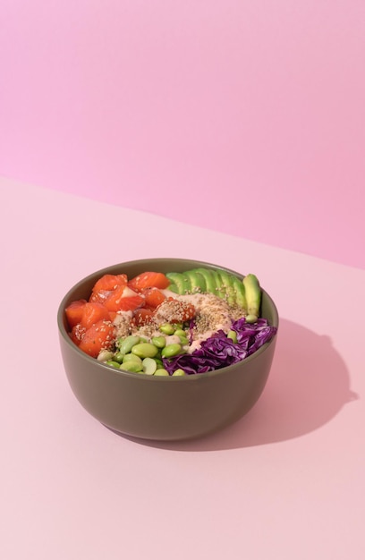 Hawaiian fish salmon poke bowl on pink background hard shadows minimalism