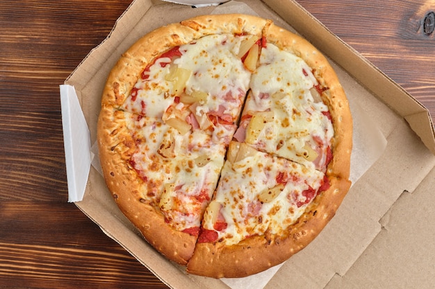 Hawaiian pizza in a carton with top view