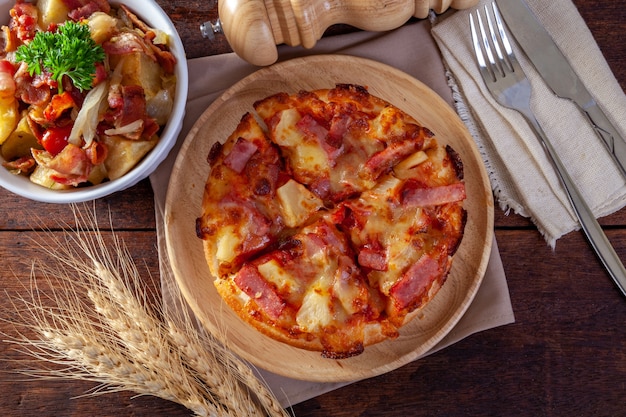 Hawaiian pizza on wood plate