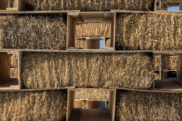 Photo hay bales are stacked in large stacks forming a wall