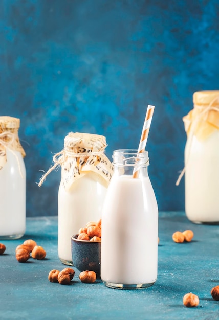 Hazelnut milk on blue table background Non dairy alternative vegan drink Negative space