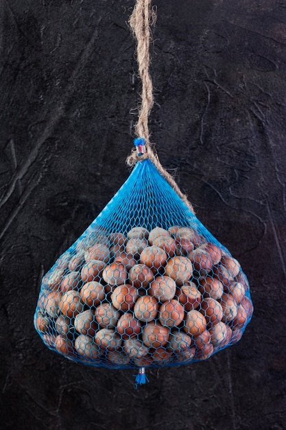 Hazelnut net hangs against a dark background