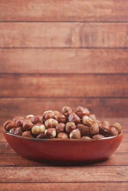 Hazelnuts in a container on black background