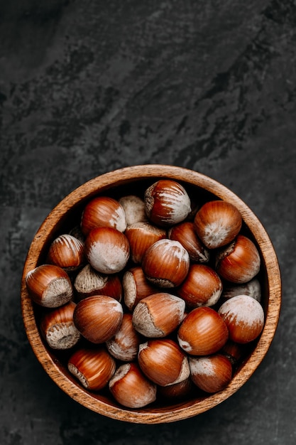 Hazelnuts Whole Hazelnuts in wooden bowl on dark background