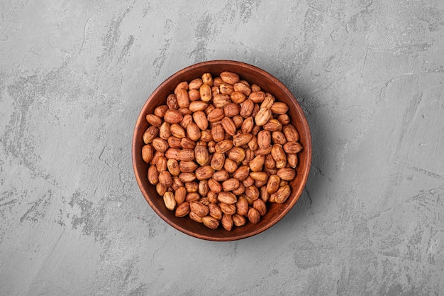 Hazelnuts in wooden bowl on concrete background natural healthy vegan food top view