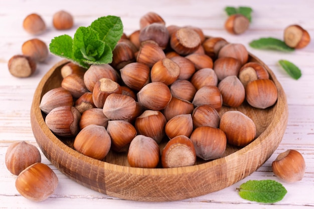 Hazelnuts in a wooden bowl on a white background