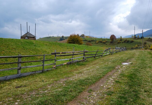 Hazy and overcast autumn Carpathian Mountains and dirty countryside path Ukraine