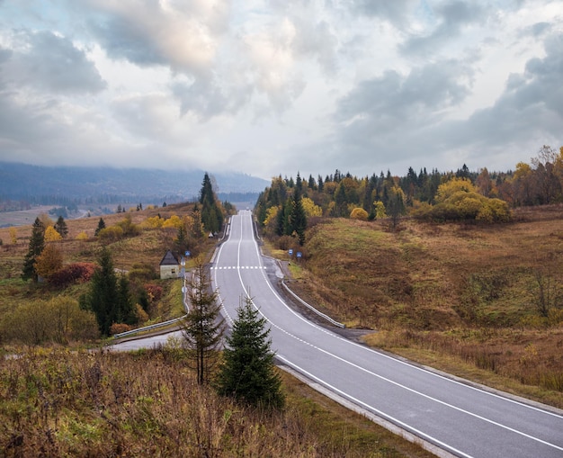 Hazy and overcast Carpathian Mountains and highway on mountain pass Ukraine