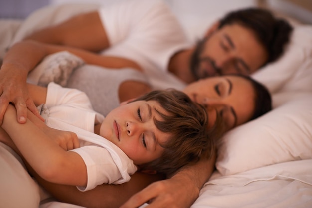 He always wants to be close to mommy and daddy Cropped shot of a young family in bed together