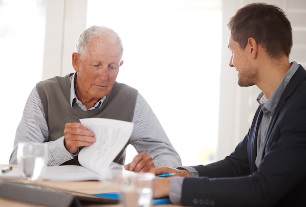 He has a good understanding of his coverage now A young businessman explaining information to an elderly man