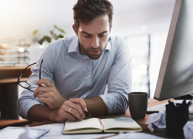 He keeps a close eye on every detail Shot of a young businessman working late in an office