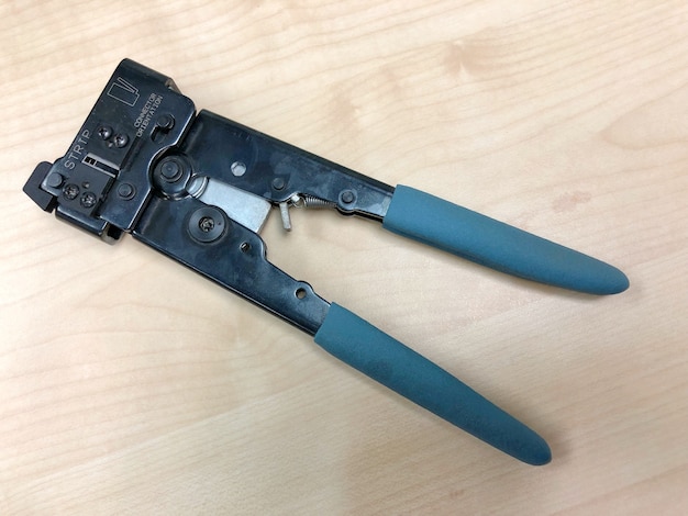 he pliers tool with blue handles for crimping a connector to network and telephone cable