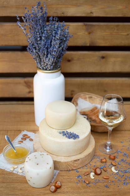 Head of fresh organic cheese is served with bread nuts white wine and lavender