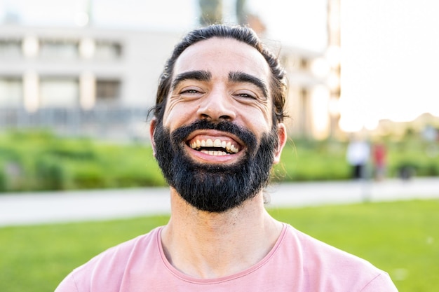 Head shoot of an hispanic bearded man smiling at the camera