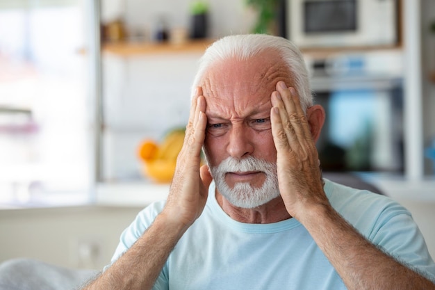 Headache Senior Man Suffering From Migraine Pain Massaging Temples Sitting At Home Healthcare Health Problems In Older Age Concept