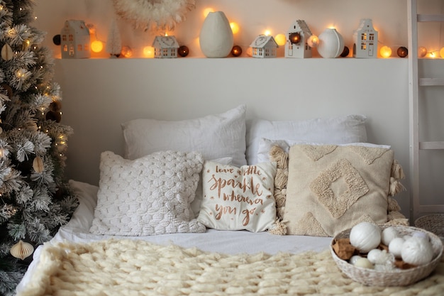 Photo headboard bed with new year pillows and christmas decor and glowing garlands