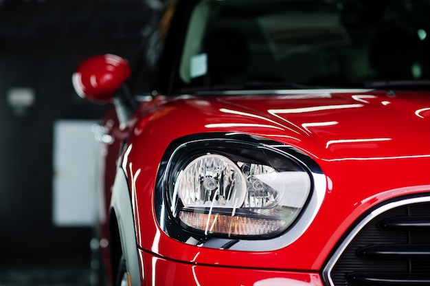 Headlights and hood of sport red car in garage