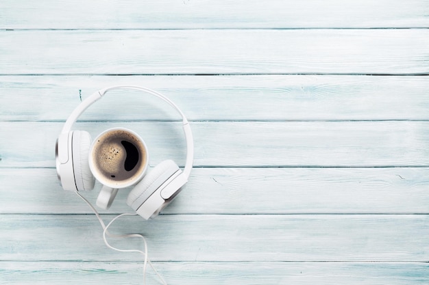 Headphones and coffee cup on wooden table