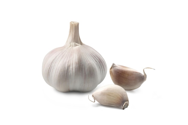 Heads of garlic with cloves of garlic placed on a white