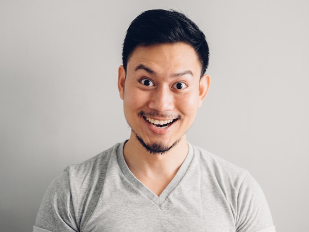 Headshot photo of Asian man with happy face. on grey background.