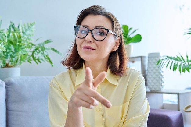 Headshot portrait of middle aged woman looking at webcam