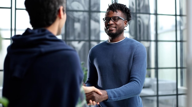 Headshot portrait of a smiling businessman offering a handshake business concept