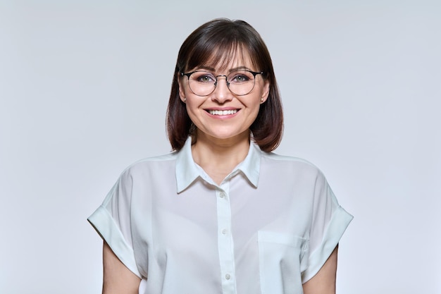 Headshot portrait of smiling middle aged woman looking at camera