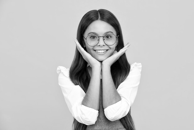 Headshot portrait of teenager child girl isolated on studio background Childhood lifestyle concept Mock up copy space Happy girl face positive and smiling emotions