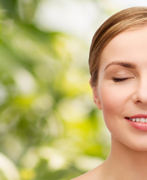 health and beauty concept - closeup of face of beautiful young woman with closed eyes