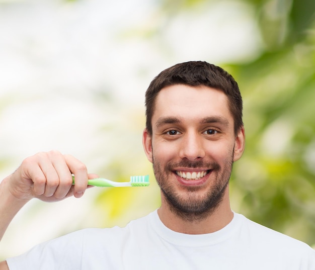 health and beauty concept - smiling young man with toothbrush