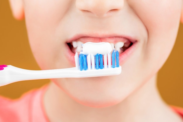 Health care, dental hygiene. Joyful child shows toothbrushes. Little boy cleaning teeth. Dental hygiene. Happy little kid brushing her teeth. Kid boy brushing teeth. Boy toothbrush white toothpaste.