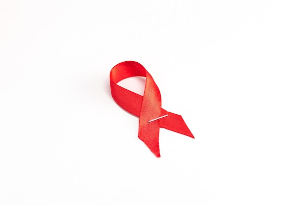 Health care and medicine concept. AIDS awareness. Red awareness ribbon on white background. International AIDS Day