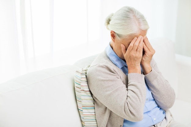 health care, pain, stress, age and people concept - senior woman suffering from headache or grief