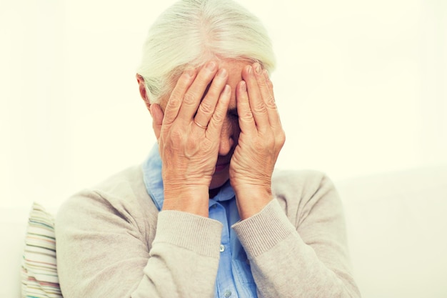 health care, pain, stress, age and people concept - senior woman suffering from headache or grief