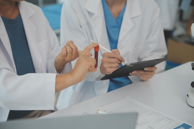 Health care researchers working in life science laboratory Young female research scientist and senior male supervisor preparing and analyzing microscope slides in research lab