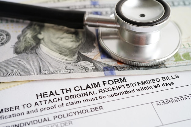 Health claim form with stethoscope and US dollar banknotes insurance accident medical concept