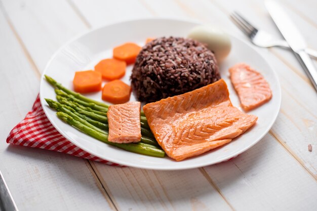 Health food concept, salmon with rice and vegetable on wood background 