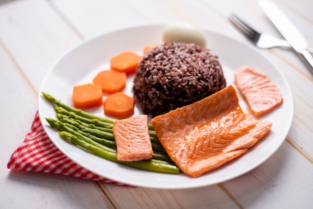 Health food concept, salmon with rice and vegetable on wood background 