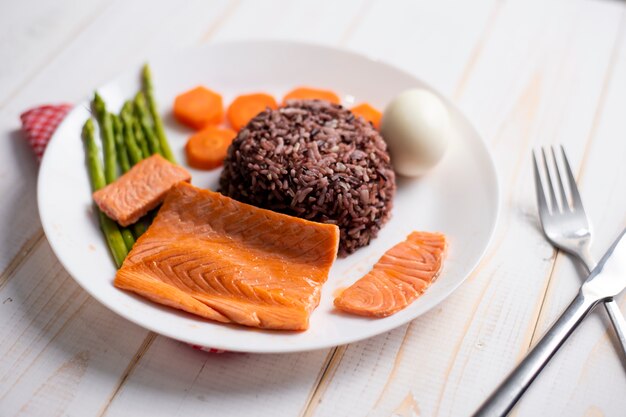 Health food concept, salmon with rice and vegetable on wood background 