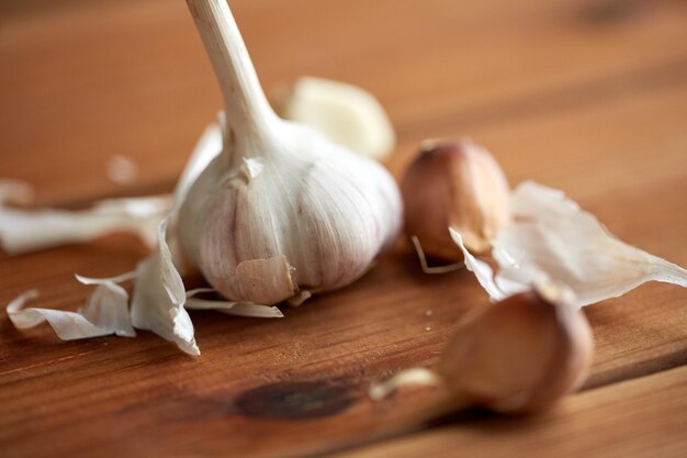 Photo health, food, cooking, traditional medicine and ethnoscience concept - close up of garlic on wooden table